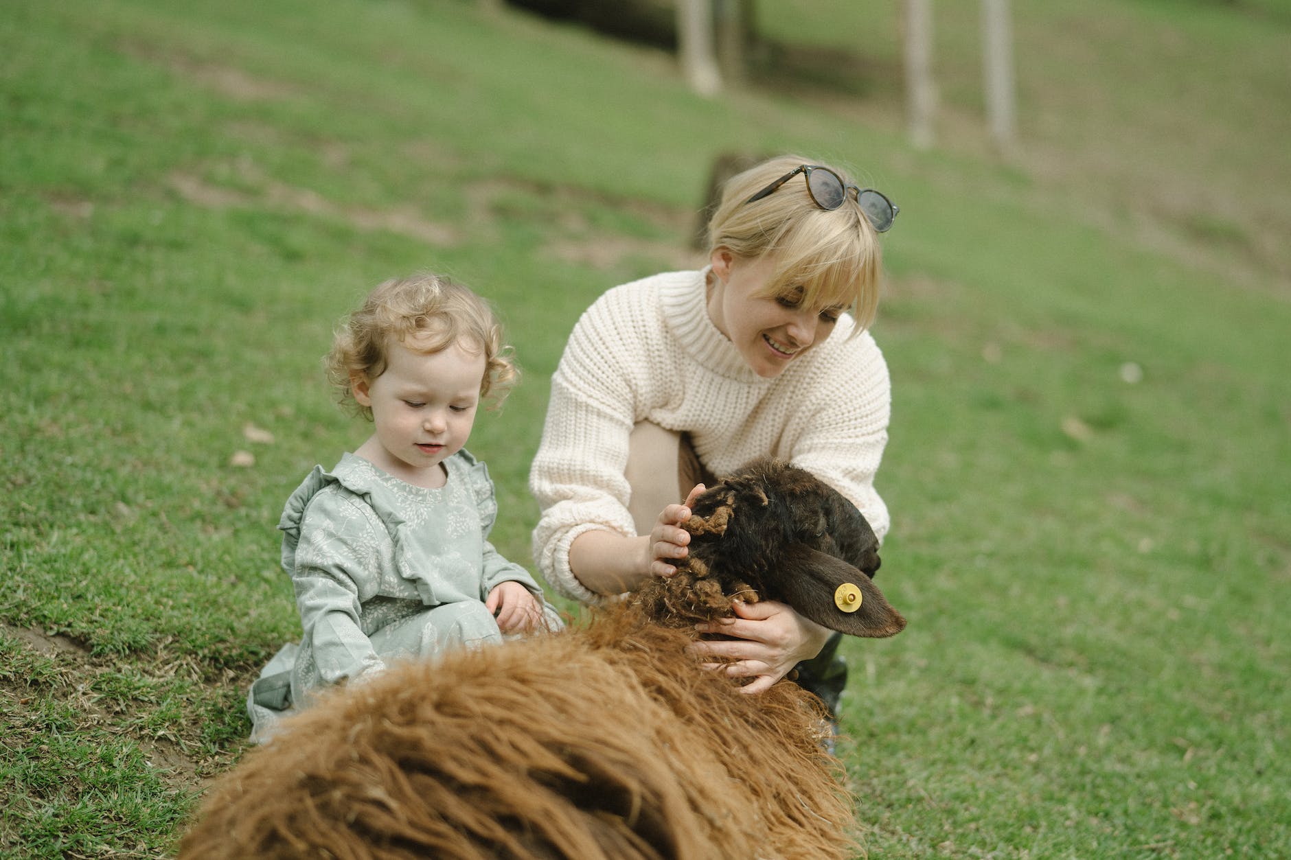 mother and daughter holding a brown animal